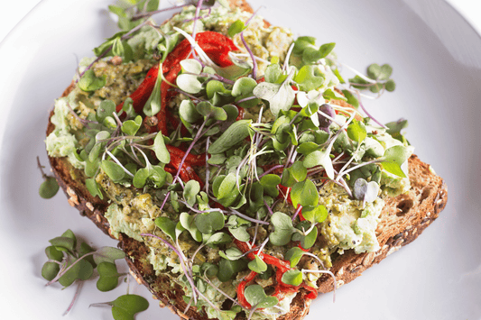 Healthy avocado and microgreen toast with balsamic glaze and red pepper flakes.