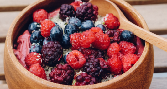 A vibrant purple Merry Berry Smoothie in a glass, garnished with a dash of cinnamon and fresh berries, inspired by a Seasonal Garden Kit.