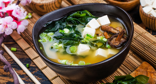 A steaming bowl of Nutrient-Dense Miso Soup with tofu, shiitake mushrooms, and vibrant green bok choy harvested from a Seasonal Garden Kit.