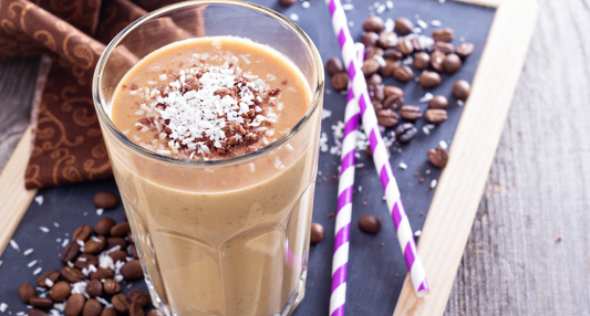 A creamy, chocolate-colored Mocha Smoothie in a tall glass, garnished with cocoa nibs and served alongside a fresh apple from a Seasonal Garden Kit.