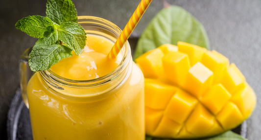 A vibrant Tropical Immunity Smoothie in a glass, featuring fresh mango, pineapple, and leafy greens harvested from a Seasonal Garden Kit.